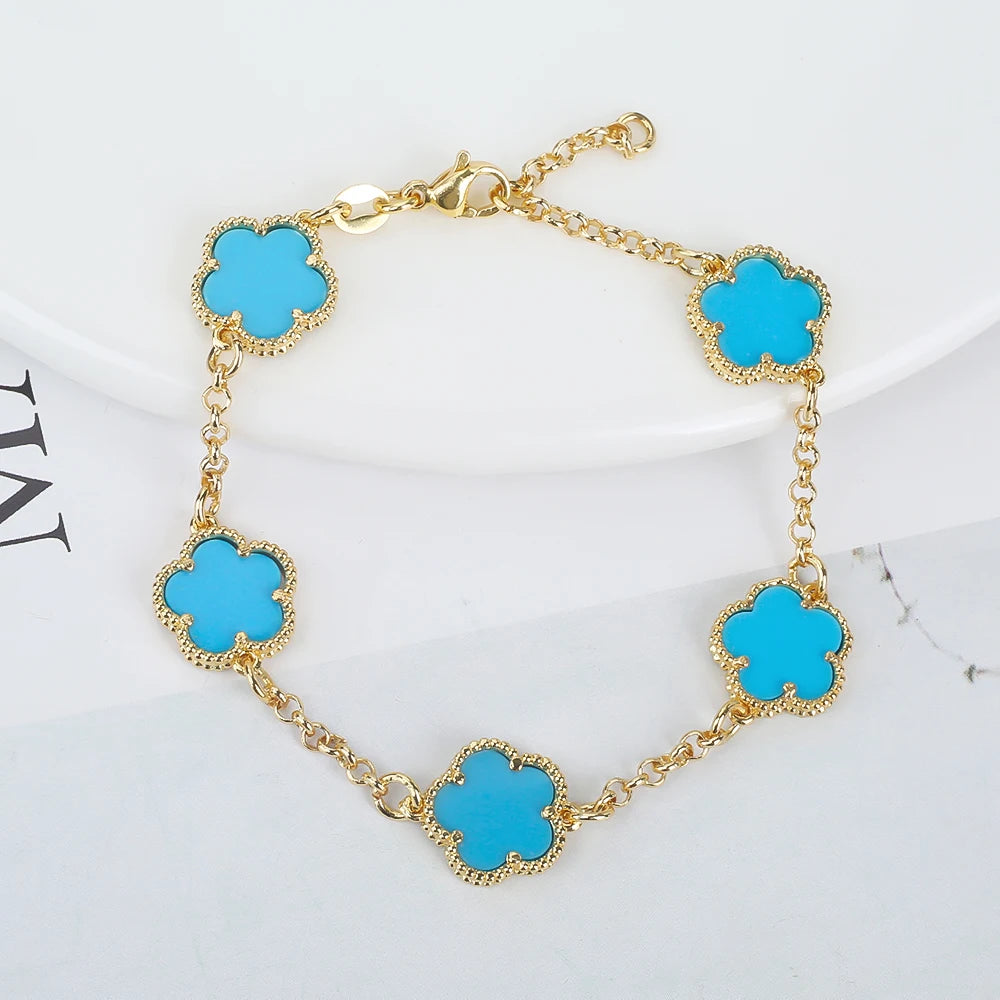 Gold plated chain bracelet with five turquoise clover charms, adjustable clasp for daily accessory wear.