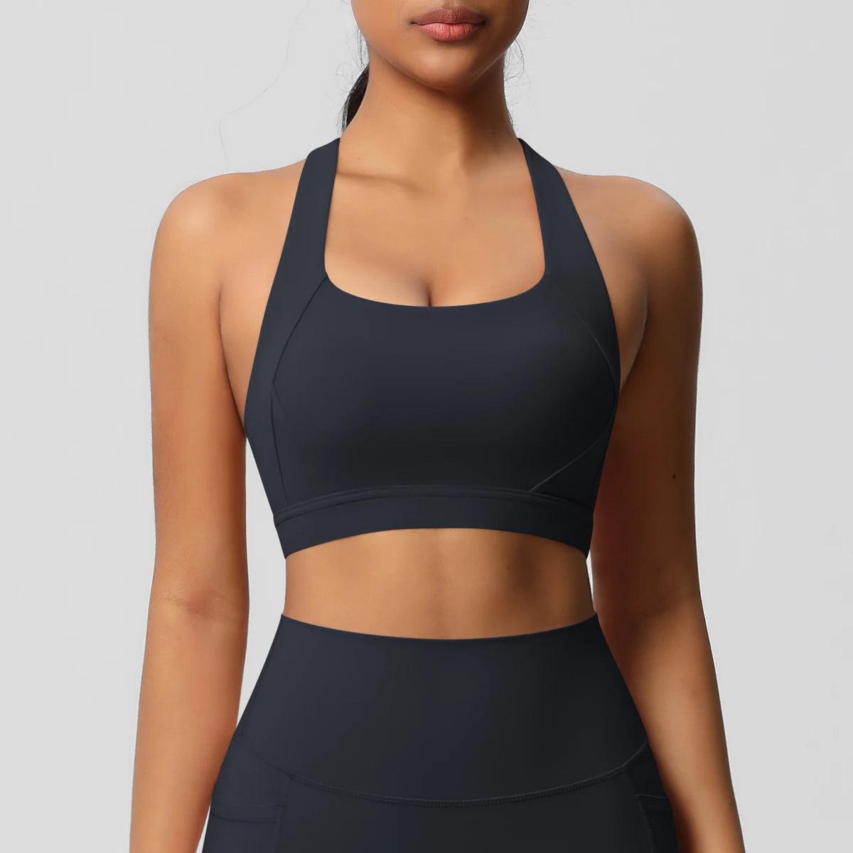 Black nylon seamless sculpting yoga bra with a supportive sling back for workouts.