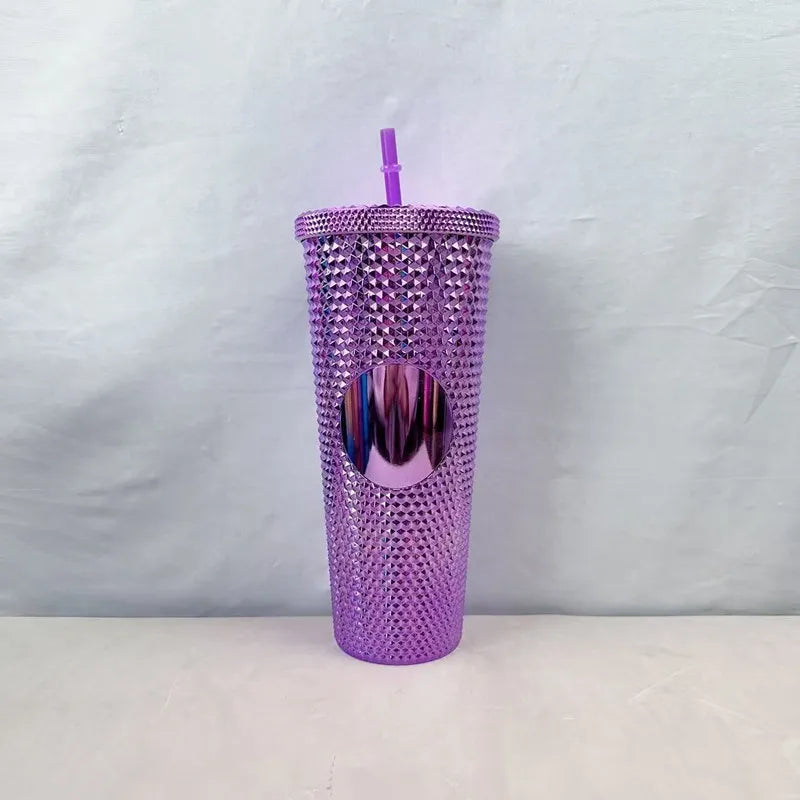 Purple studded double-walled tumbler with straw for iced coffee, featuring a smooth circular center emblem.