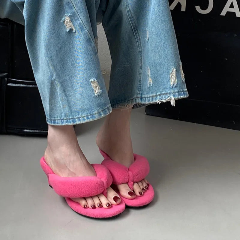 Hot pink cushioned wedge slides with a thick strap for comfortable travel wear.