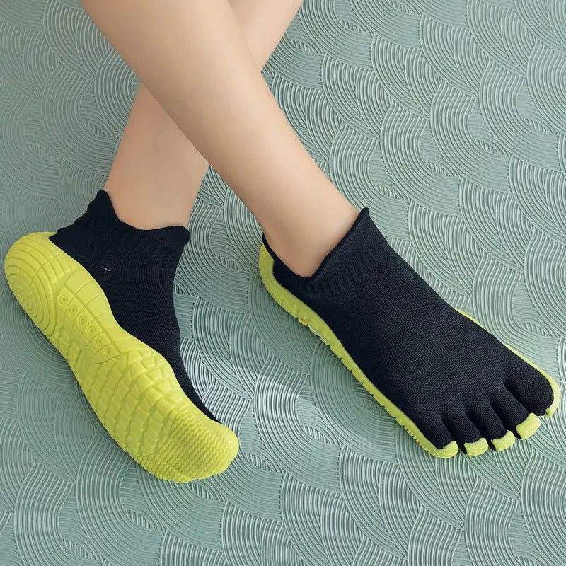Black and lime green split-toe barefoot shoes with non-slip soles for natural ground feel during outdoor exercise.
