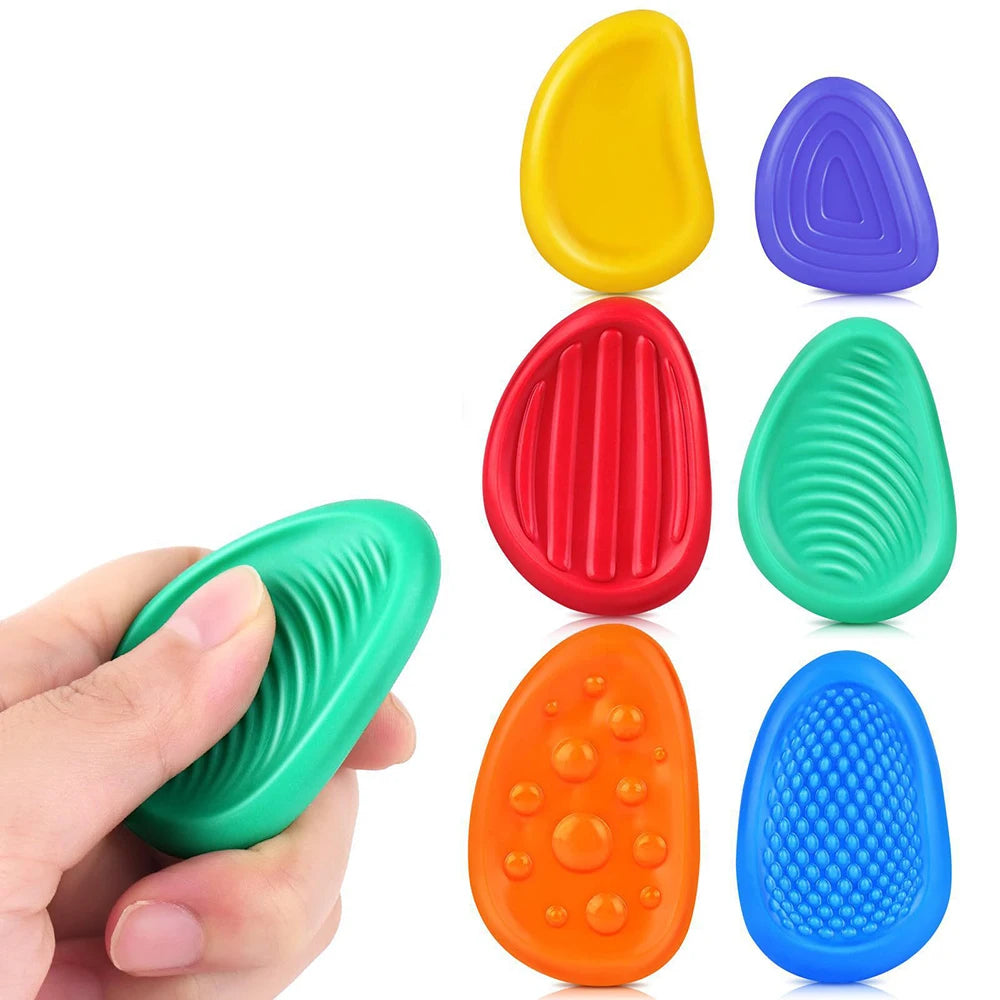 Six colorful silicone fidget toy stones with textured surfaces for sensory relief and calming play.