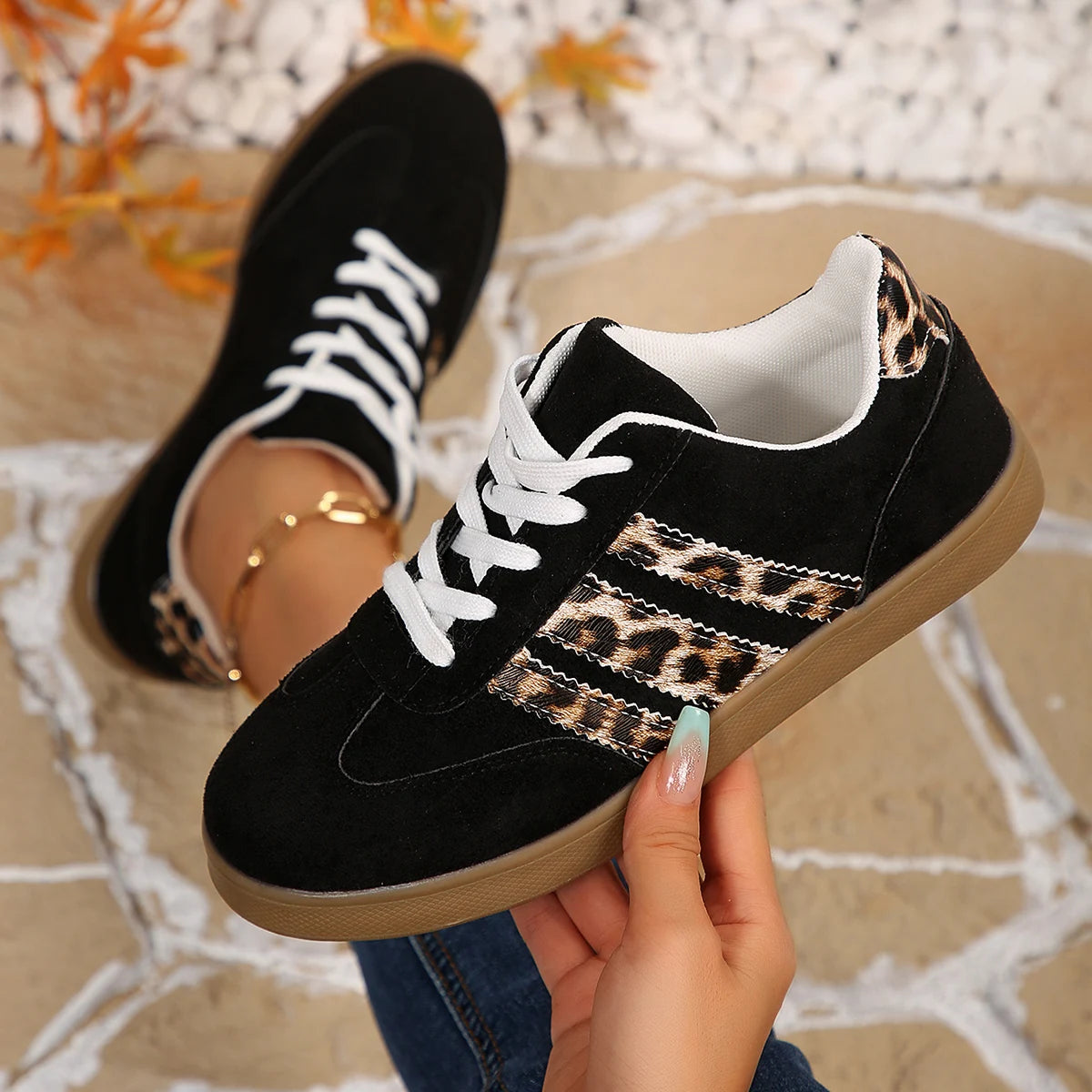 Black suede and leopard print cushioned slip-on sneakers with white laces for comfortable everyday outdoor wear.