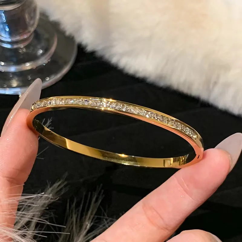 Gold stainless steel bangle bracelet with clear rhinestones for formal wear accessories.