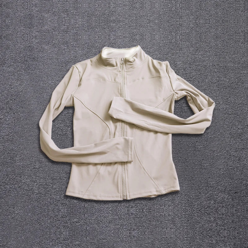 Beige long-sleeve polyester sport jacket with a fitted design, zip closure, and seams for gym training and yoga.