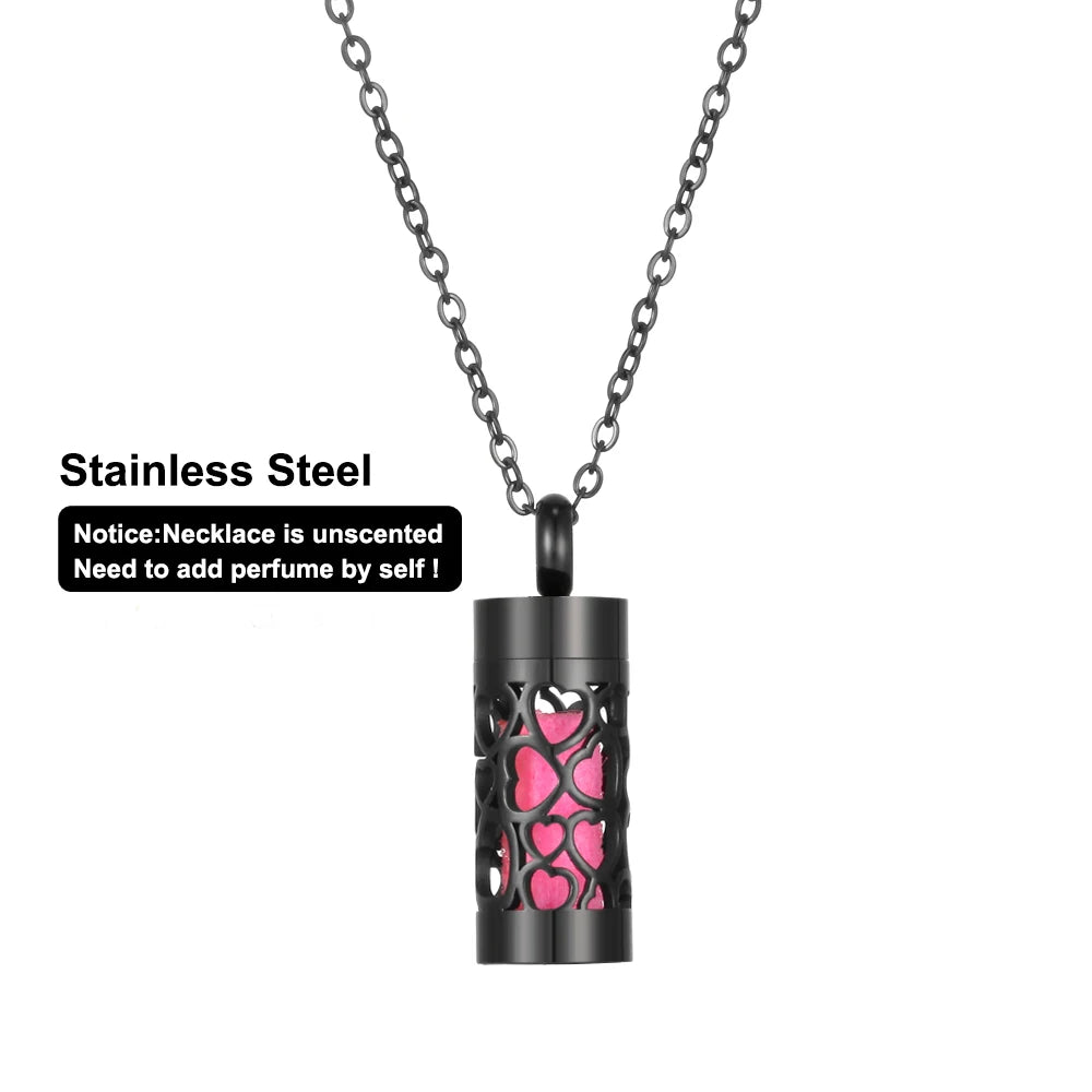 Black stainless steel cylinder aromatherapy necklace with heart cutouts and pink insert for personal essential oil use.