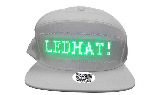 White fabric baseball cap featuring a green LED display for customizable text as a smart wearable for events.