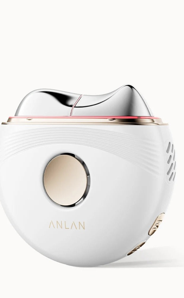 White electric facial massager with a smooth silver curved contour head and round gold button.