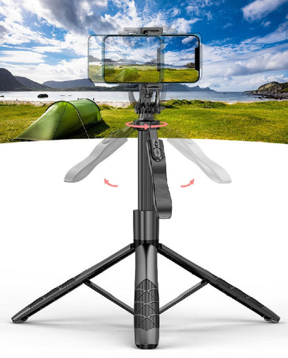 Black phone gimbal tripod with adjustable legs and remote control, set against an outdoor landscape backdrop.