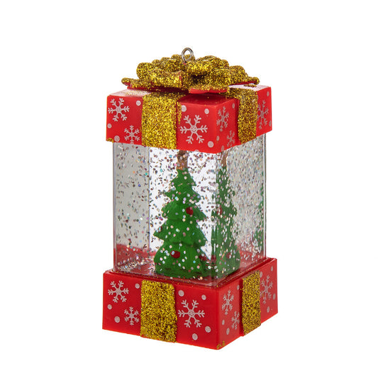 Red and gold glittery present-shaped Christmas snow globe ornament with green trees inside