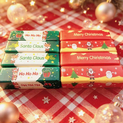 Multiple Christmas butter stick squishy toys with holiday designs on red plaid background.