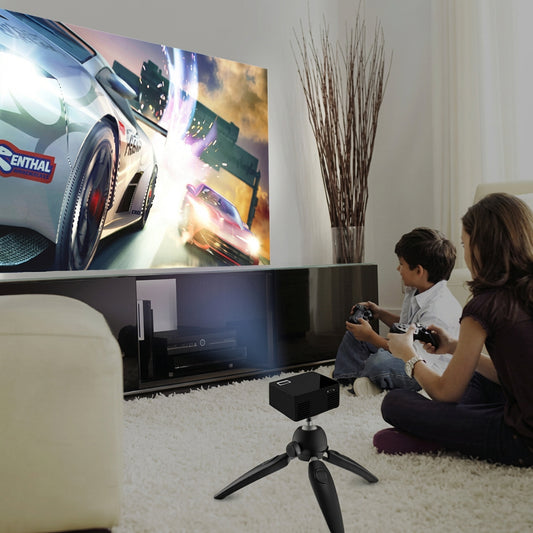 Mini projector on a tripod projecting a racing video game on the wall for two children playing with controllers.