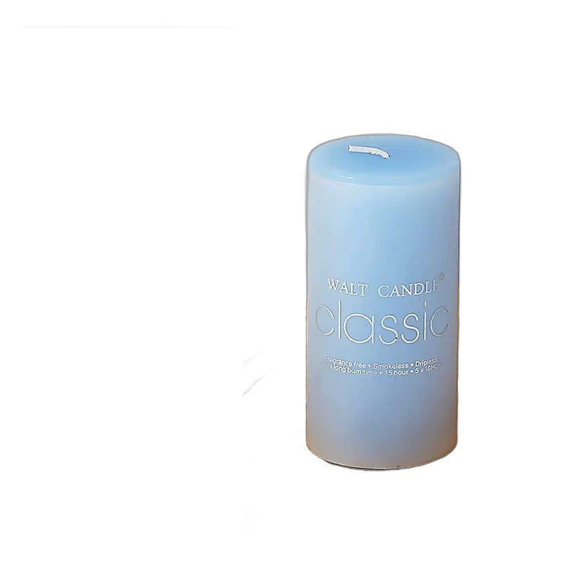 Home decor scented blue cylindrical wax pillar candle on a wooden tray with an ocean
