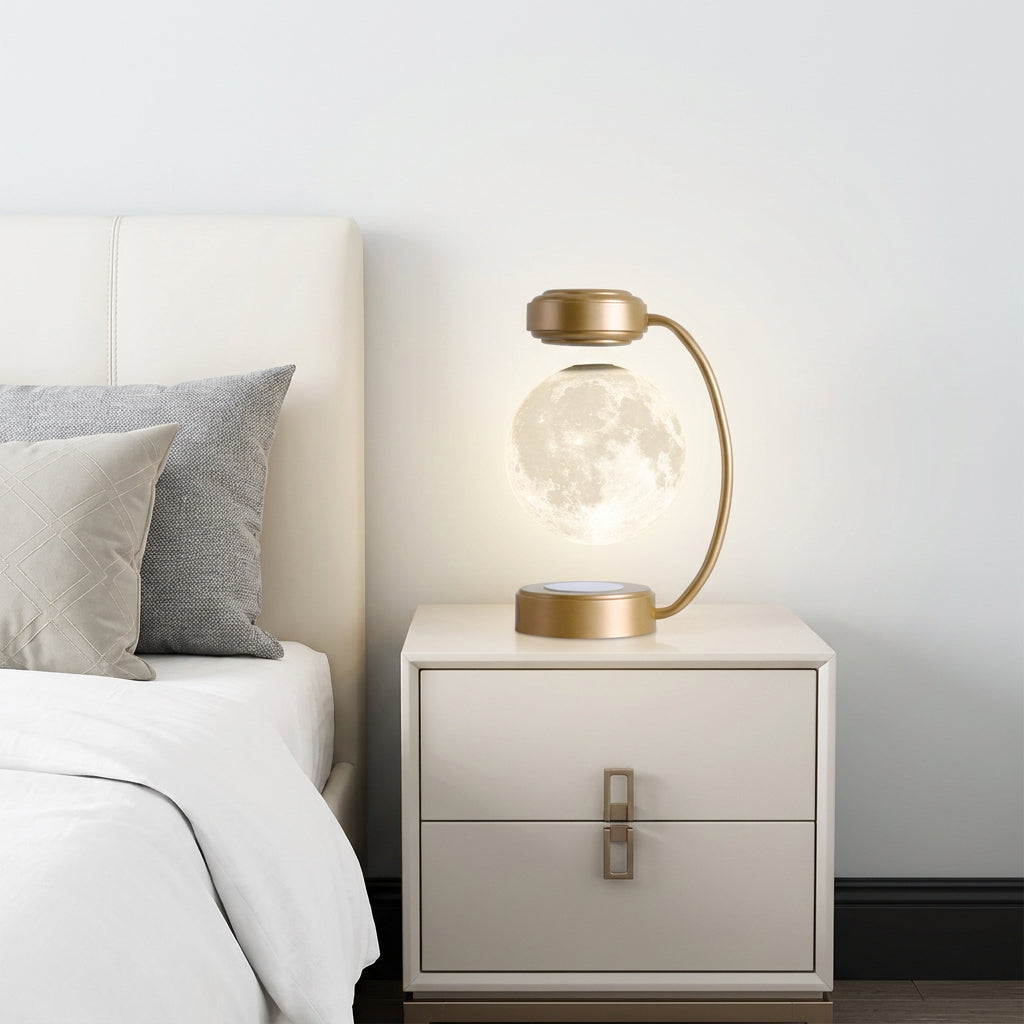 Gold levitating moon lamp on a nightstand beside a bed