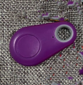 Purple teardrop-shaped Bluetooth tracker with a central button and keyring hole to locate keys and bags.