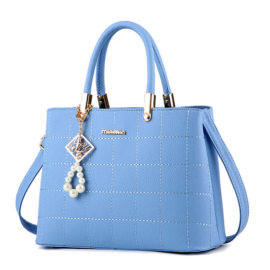 Light blue quilted crossbody bag with pearl accent and top handles