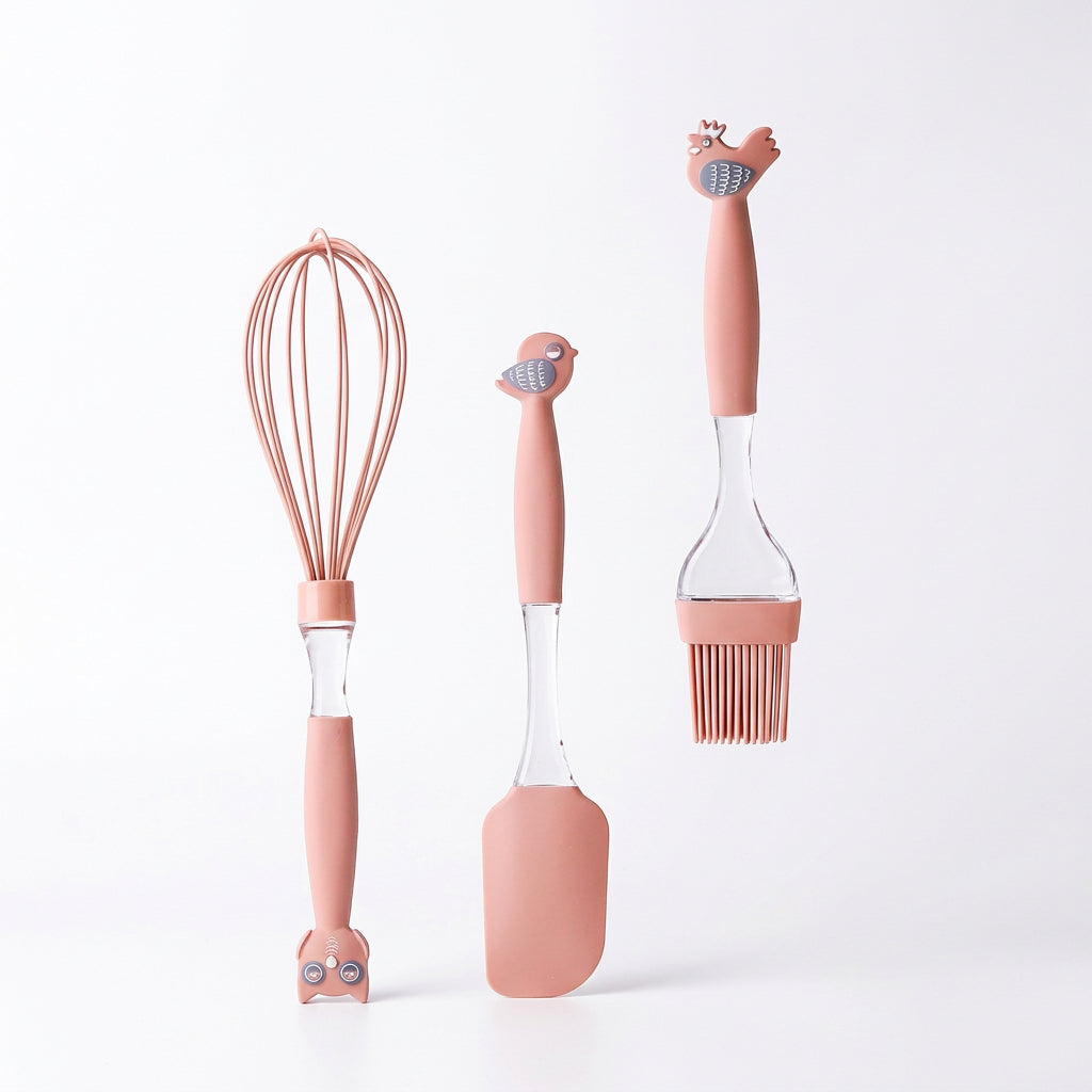 Pink silicone baking utensil set including a whisk, spatula, and pastry brush with cute animal toppers.