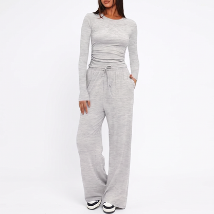 Grey ribbed two-piece loungewear set featuring a long-sleeve top and high-waist wide-leg pants with a drawstring.