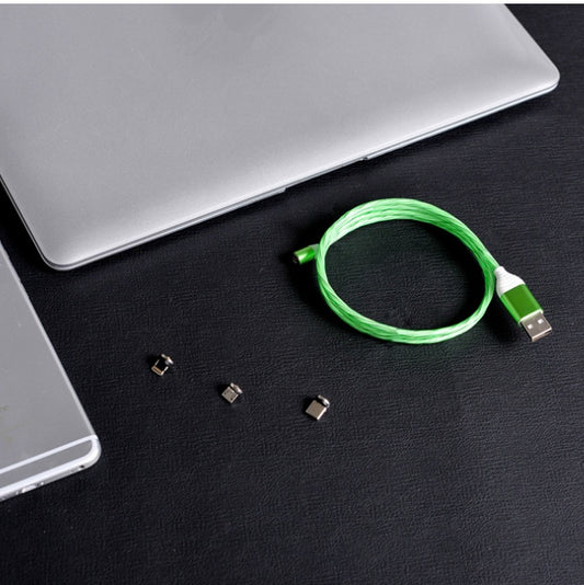 Green braided magnetic charging cable with three interchangeable tips next to a laptop.