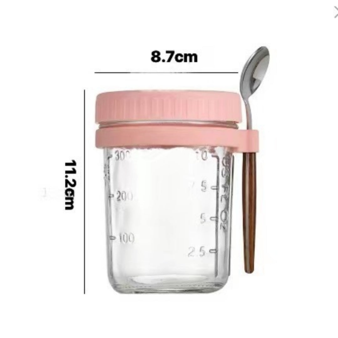 Overnight oats glass cup with pink lid and spoon showing dimensions.