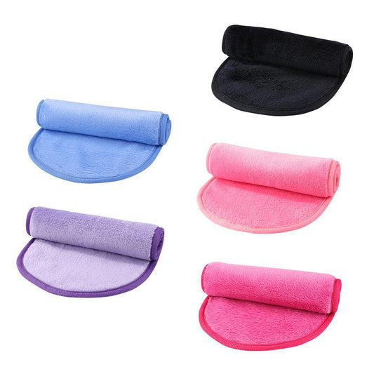 Five colorful microfiber cleansing pads in black, blue, purple, pink, and red, each folded with a rolled top.