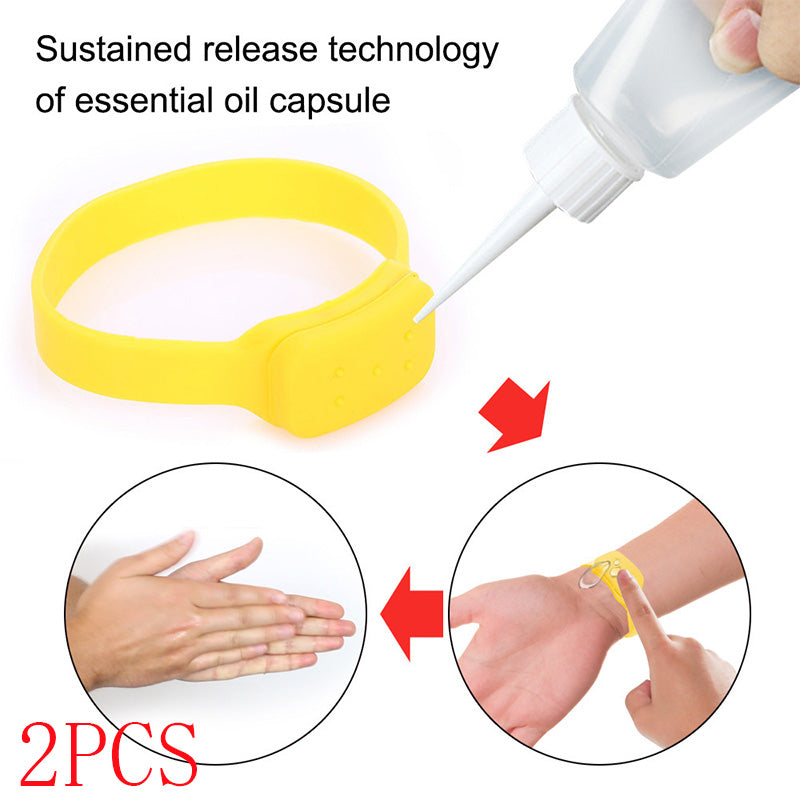 Yellow silicone refillable dispenser bracelet being filled from a squeeze bottle and worn on a wrist.