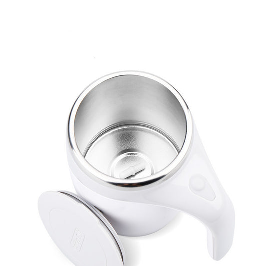 Top-down view of a white self-stirring mug with metal interior lining, visible magnetic pill stirrer, and detached lid.