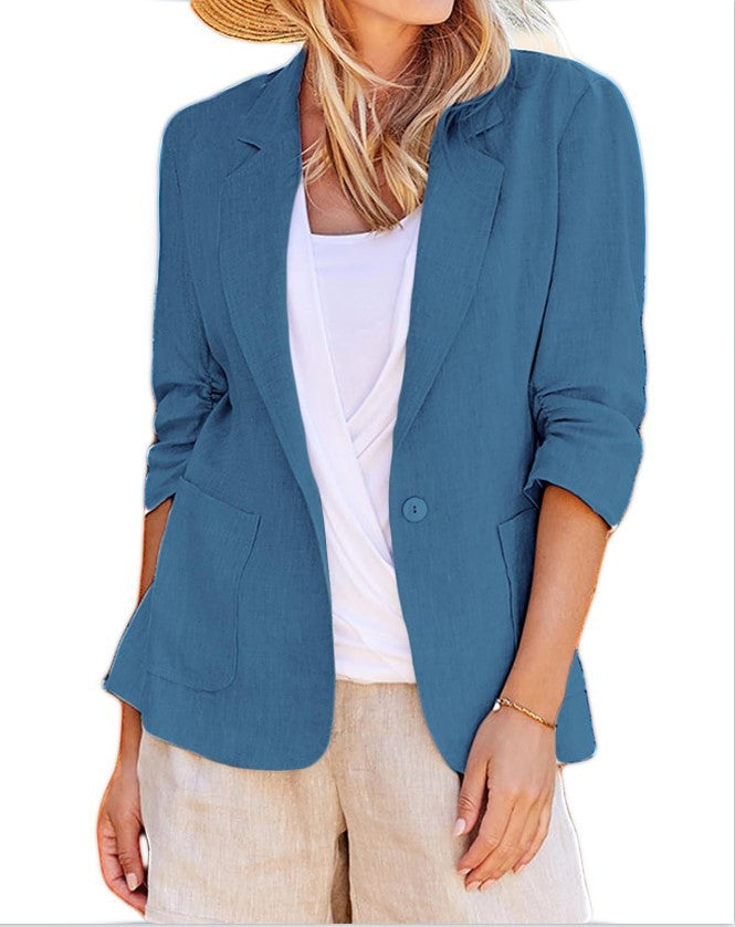 Woman wearing an open-front blue blazer jacket over a white top with front patch pockets and rolled sleeves.