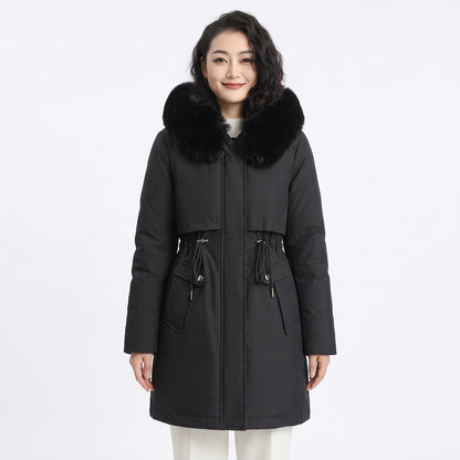 Woman wearing a black puffer coat with a large black faux fur collar and drawstring waist.