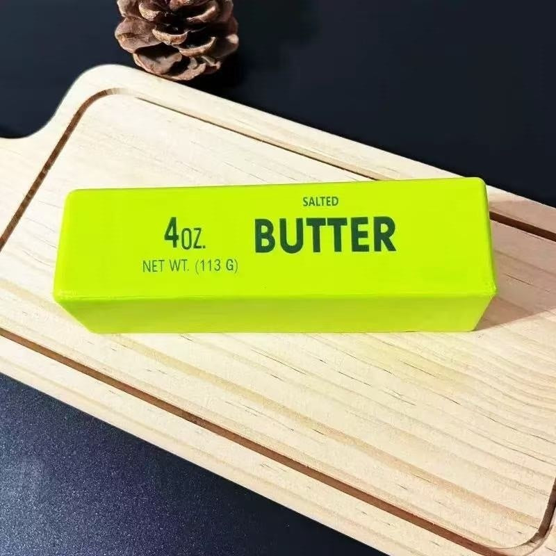 Salted butter stick squishy toy resting on a wooden tray