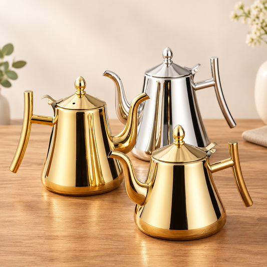 Three polished stainless steel teapots in gold and silver finishes on a wooden surface.