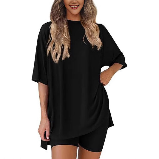 Woman wearing a black oversized t-shirt and matching bike shorts lounge set.