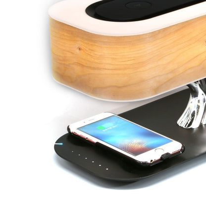 Smartphone resting on the black base of a wood grain bedside lamp