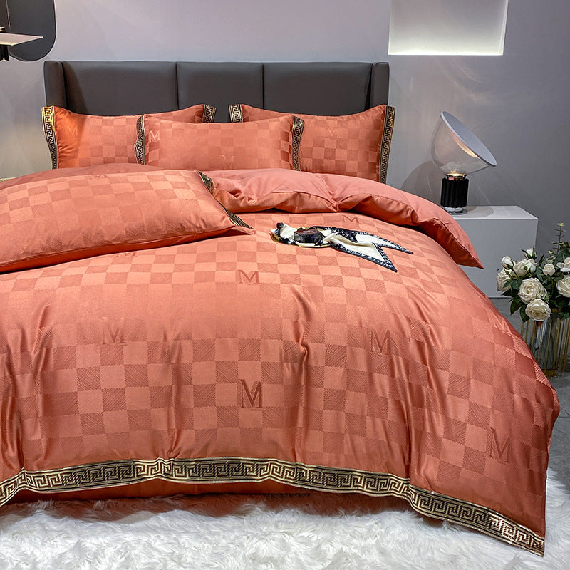 Orange checkerboard duvet cover set with a black and gold geometric border on a bed.