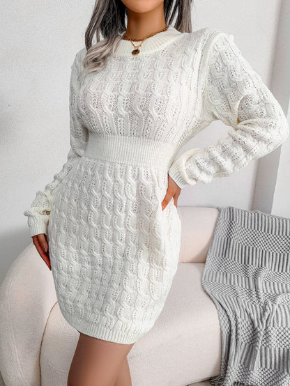 White cable knit sweater dress with a fitted waist, worn for cold weather style.