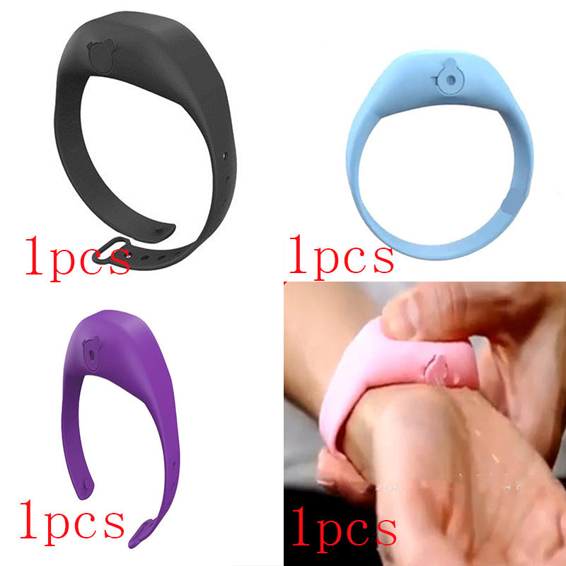 Four silicone hand sanitizer dispenser wristbands in black, blue, purple, and pink shown being squeezed on a wrist.