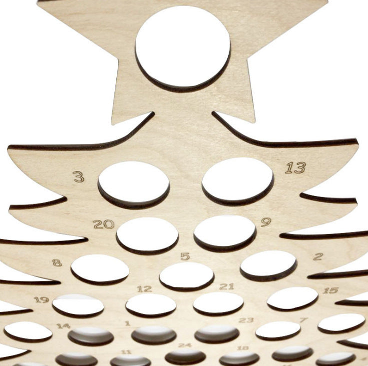 Close-up of wooden tree-shaped advent calendar with numbered circular cutouts.