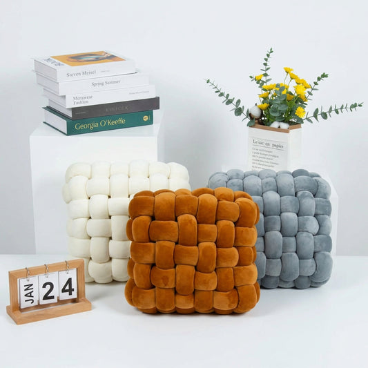 Handwoven plush sofa cushions in white, brown, and grey on a light sofa