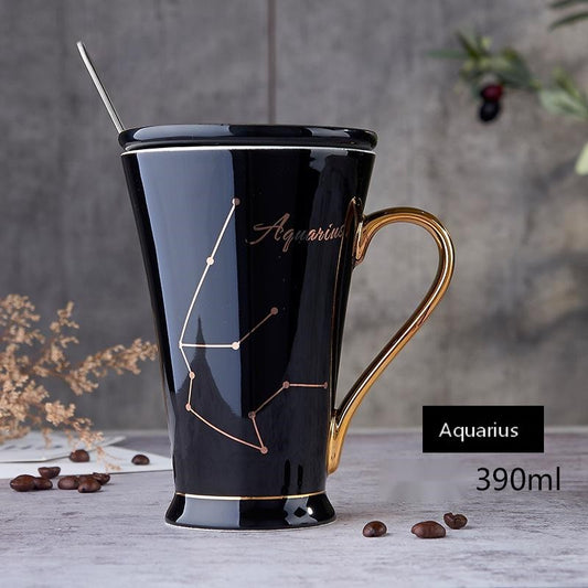 Black ceramic coffee mug featuring gold Aquarius constellation, matching lid, spoon, and gold handle.