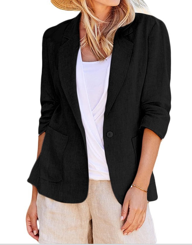 Woman wearing a black single-button blazer over a white top and tan shorts.
