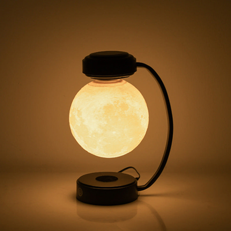 Levitating moon lamp glowing in a dark room, close-up