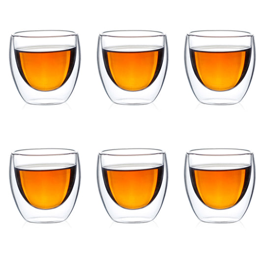 Six clear double-wall glass teacups filled with amber tea arranged in two rows.