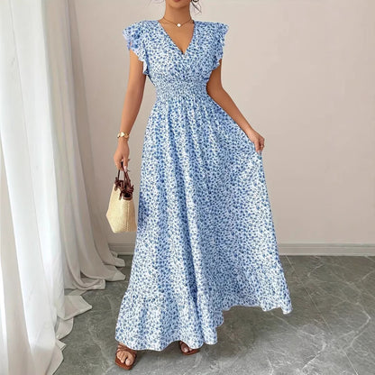 Blue floral flowy polyester dress with flutter sleeves, worn as resortwear.