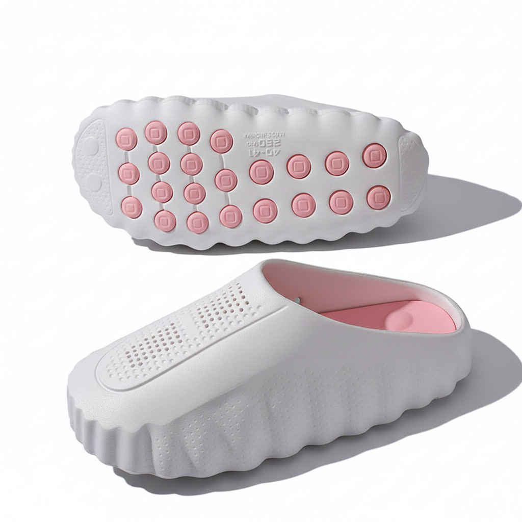 White rubber slip-on clogs with pink insoles and textured grip soles on white background.