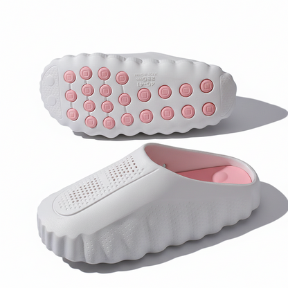 White rubber slip-on clogs with pink insoles and textured grip soles on white background.