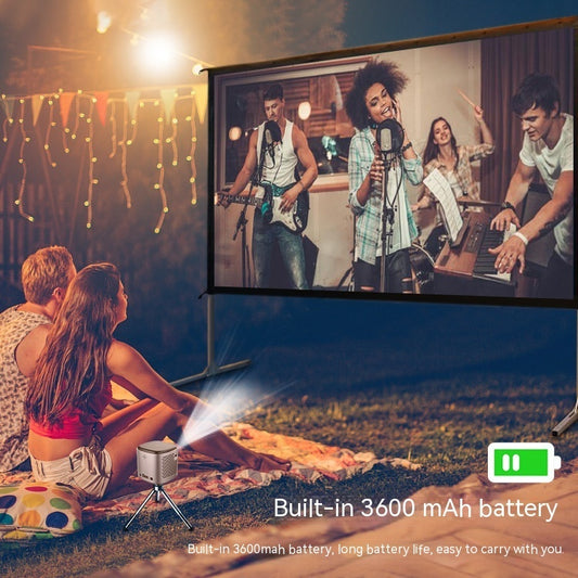 Mini projector on tripod projecting a band performing on an outdoor screen for a couple sitting on a blanket.