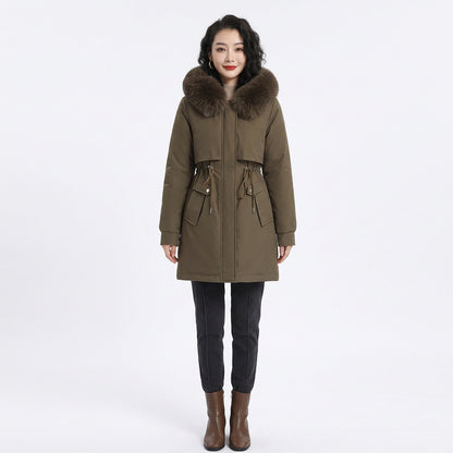 Woman wearing an olive green puffer coat with a fluffy fur-trimmed hood and drawstring waist.
