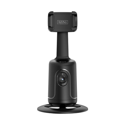 Black smartphone tracking holder on a circular base with an adjustable clamp and built-in camera lens.
