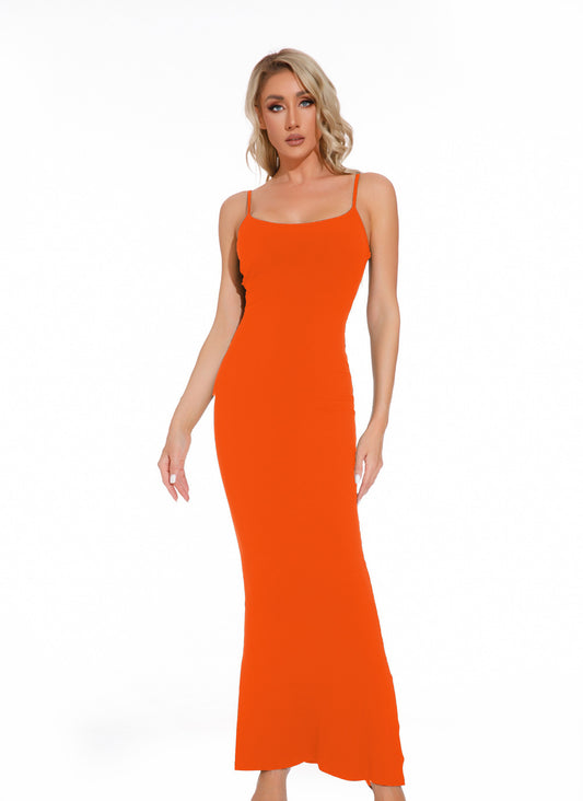 A woman wearing a vibrant orange maxi slip dress with thin spaghetti straps.