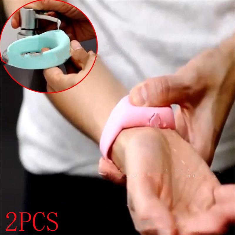 Person wearing a pink silicone dispenser bracelet on their wrist and dispensing liquid onto their hand